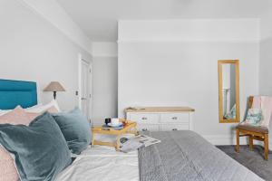 达特茅斯THE ANGEL 2 BEST VIEWS IN DARTMOUTH的一间卧室配有一张带蓝色枕头的床和一张桌子