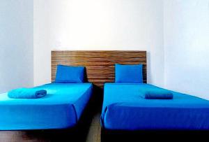 长滩岛RedDoorz at Sir G Hotel D'Mall Boracay的两张带蓝色枕头的床