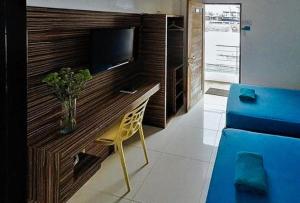 长滩岛RedDoorz at Sir G Hotel D'Mall Boracay的一间带电视和黄椅的客厅