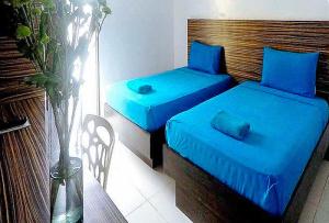 长滩岛RedDoorz at Sir G Hotel D'Mall Boracay的客房内的两张床和蓝色床单