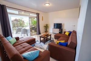 TohautuNoha Lodge的一间带2张棕色沙发的客厅和一个阳台