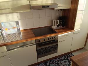 巴特基辛根Ferienwohnung zum Glück的厨房配有白色橱柜和炉灶烤箱。