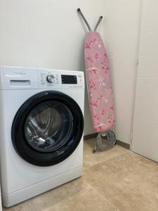 格里莫Chambre de charme n2的洗衣机,墙上挂着粉红色毛巾