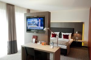 肯普滕阿尔古大盒子酒店的酒店客房设有一张床和墙上的电视