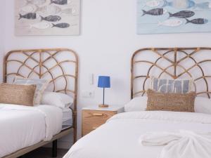 马塔罗Matarolux24的卧室内的两张床,配有白色床单和枕头