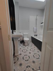 都柏林Modern 4 Bedroom Townhouse in City Centre的浴室配有卫生间、盥洗盆和浴缸。
