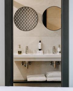 圣塞瓦斯蒂安HOTEL ARRIZUL CATEDRAL的一间带水槽和两面镜子的浴室
