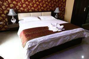 芭堤雅市中心The Pattaya Sports Hub的一间卧室配有一张大床,上面有白色的花朵