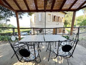 圣吉米纳诺Casale di Valle Mora的露台上的玻璃桌子和椅子