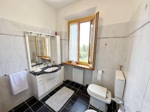 圣吉米纳诺Casale di Valle Mora的一间带卫生间、水槽和镜子的浴室