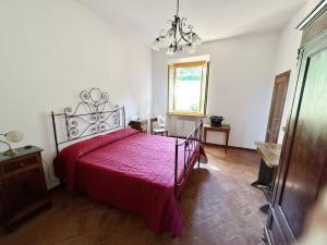 圣吉米纳诺Casale di Valle Mora的一间卧室配有一张红色床罩的床