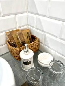 格拉纳达Hotelito Suecia的浴室柜台配有肥皂机和篮子