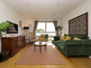 泰晤士河畔金斯顿Pass the Keys Stylish comfortable apartment in central Kingston的客厅配有绿色沙发和桌子