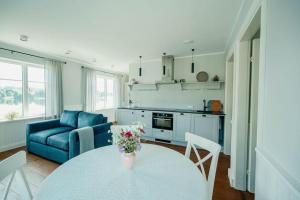 奥泰佩Väike-Juusa külaliskorter的客厅配有桌子和蓝色沙发