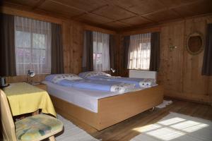 布拉伊埃斯Apartement Schuster Lake Prags Braies的一间带一张大床的卧室,位于带木墙的房间