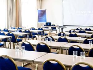 圣罗兰度瓦诺沃特尼斯机场卡普3000酒店的一间空的教室,里面配有桌椅和屏幕