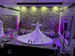 温特贝格VIP Haus Winterberg的浴室配有带紫色灯的大浴缸