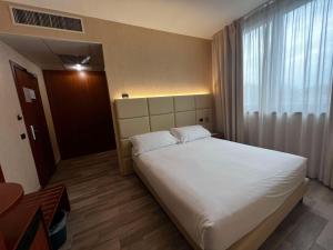 卡尔达诺阿尔坎波贝斯特韦斯特卡瓦利瑞德拉科洛纳酒店的卧室设有一张白色大床和一扇窗户。