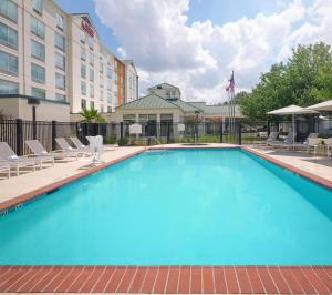 休斯顿休斯敦/布什洲际机场希尔顿花园酒店的一个带椅子的大型游泳池和一间酒店