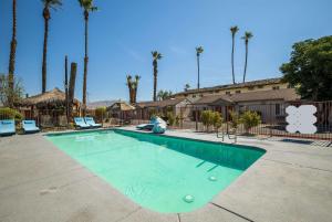 印地欧Rodeway Inn near Coachella的棕榈树停车场的游泳池