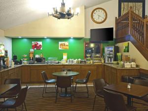 AtchisonQuality Inn Atchison的餐厅设有桌椅和墙上的时钟