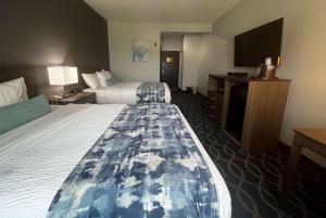 亨博尔Wingate by Wyndham Humble/Houston Intercontinental Airport的酒店客房设有两张床和一台平面电视。
