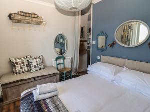 彭赞斯Starfish的一间卧室配有一张床、一张沙发和一面镜子
