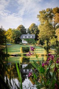 卢布林Cottage house Lublin的谷仓前带池塘和鲜花的花园