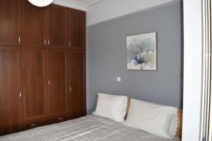 斯巴达Πολυτελές Διαμέρισμα με Θέα的一间卧室配有一张床和木制橱柜
