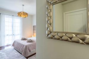 卡尼索VILLA LEONARDO的卧室配有一张床,墙上设有镜子