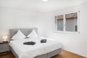 MattenNeubauwohnung mit Lift in Matten的白色的卧室设有床和窗户