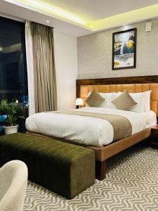 班加罗尔ROYAL ACE LUXUR的一间设有大床和窗户的酒店客房
