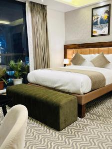班加罗尔ROYAL ACE LUXUR的酒店客房,配有两张床和椅子