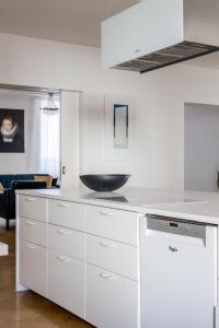 赫尔辛基Elegant City Home的厨房配有白色橱柜和碗盘