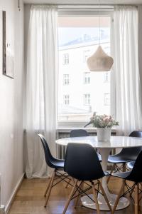 赫尔辛基Elegant City Home的一间带桌椅和窗户的用餐室