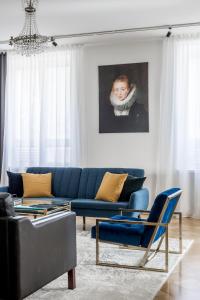 赫尔辛基Elegant City Home的客厅配有蓝色沙发和绘画作品