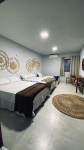 巴拉格兰德Recanto da Barra Chalé的带三张床和地毯的房间