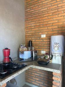 巴拉格兰德Recanto da Barra Chalé的厨房配有炉灶和微波炉