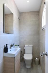 马斯帕洛马斯Duplex Los Tinos II 32 by VillaGranCanaria的浴室配有白色卫生间和盥洗盆。