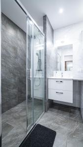 拉多姆Apartment Le Château的一间带玻璃淋浴和水槽的浴室