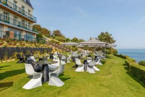 埃特勒塔多米楼酒店的一组桌子和椅子,背景是海洋