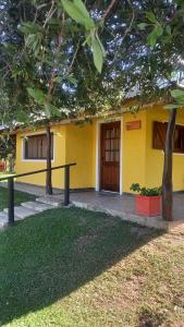 查哈里Cabañas La Soñada的一座黄色的建筑,在院子里设有木门