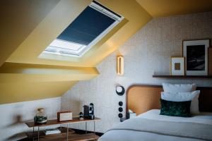 巴黎Hôtel Riesner的一间卧室配有一张带天窗的大床
