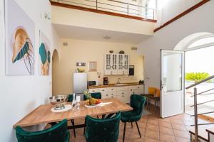 诺瓦利娅Resort Villa Moses的厨房以及带木桌和绿色椅子的用餐室。