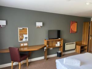考文垂Days Inn Corley NEC - M6的配有书桌和电视的酒店客房