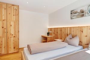 圣杰内肖阿泰西诺Tholerhof的一间卧室设有两张床和木墙
