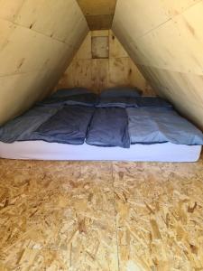 MarinciKopićland的铺有木地板的帐篷内的一张床位