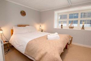 莱特肯尼Traditional Cottage with Private Hot Tub in the Heart of Donegal的卧室设有一张白色大床和一扇窗户。