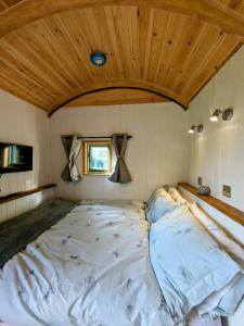 莱明斯特Herefordshire Escape, Hot Tub, Firepit, Views, BBQ的一张位于带木制天花板的客房内的大床
