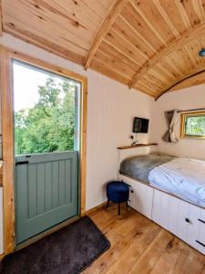 莱明斯特Romantic Escape with Hot Tub & Countryside Views的一间卧室设有一张床和一个大窗户
